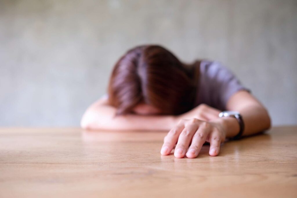 A young woman exhausted and burned out, symbolizing the struggle of staying faithful without burnout | Heaven Speaks