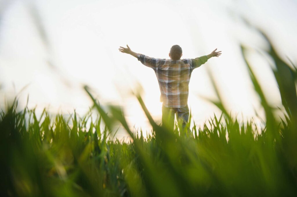 Where Do I Begin With God? Person surrendering to God daily with arms lifted in worship outside | Heaven Speaks