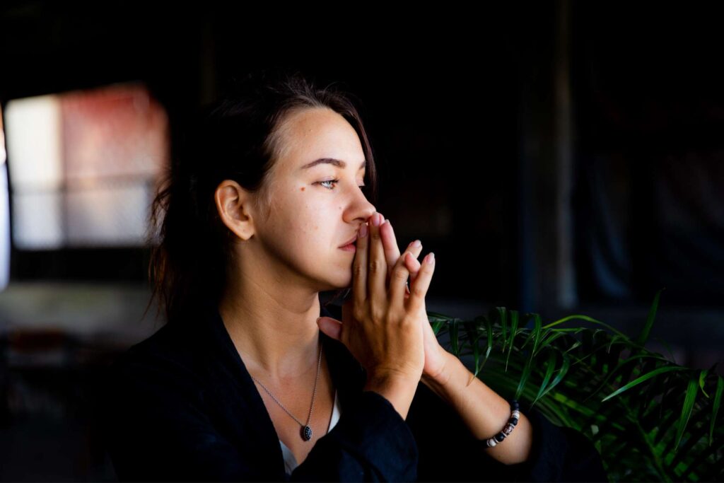 "Why Can't I Feel God?" Woman sitting quietly in prayer, listening for God’s voice and seeking peace when she can’t feel His presence.