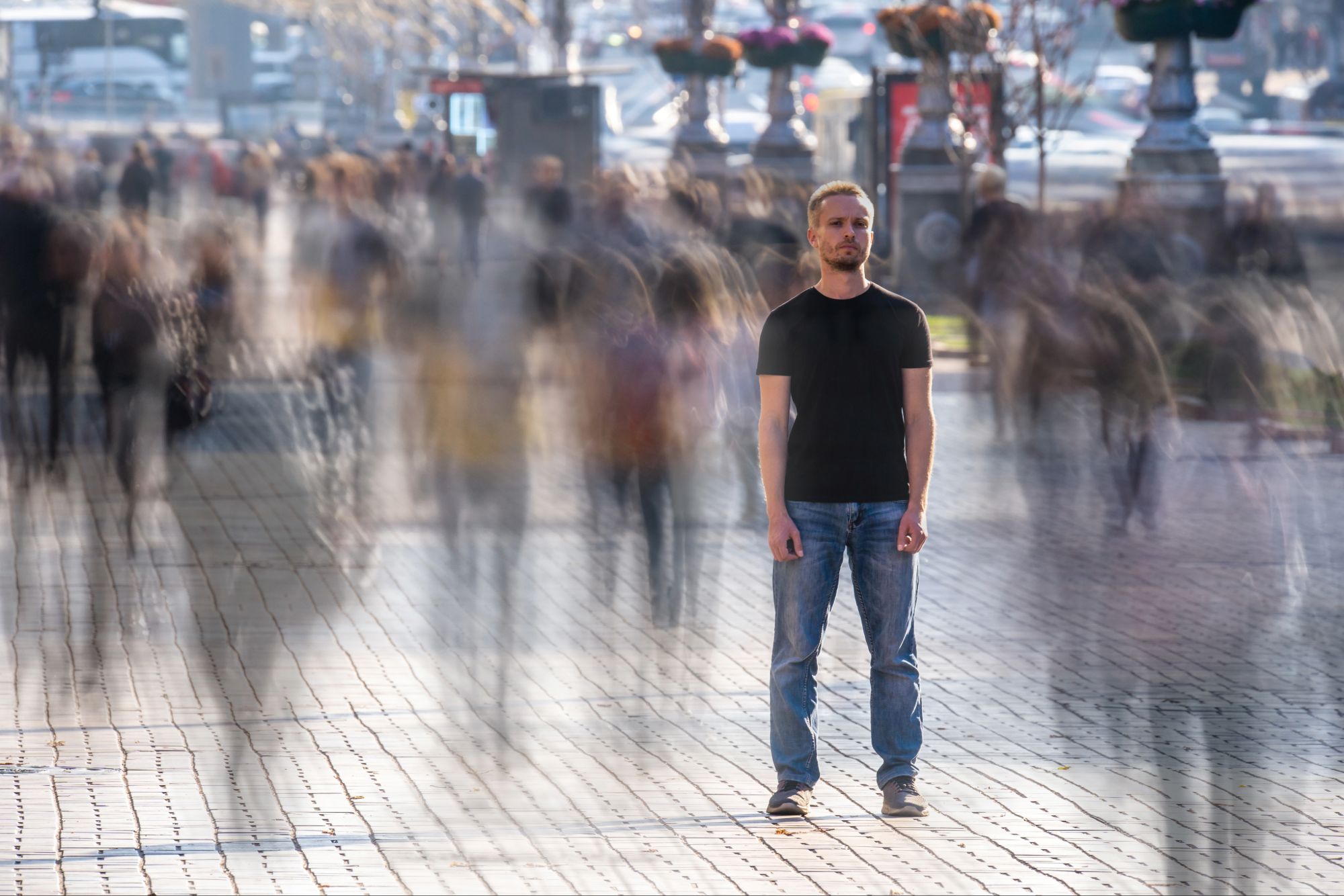 Man standing still in a busy crowd, representing feeling spiritually sensitive and overwhelmed before finding peace and discernment
