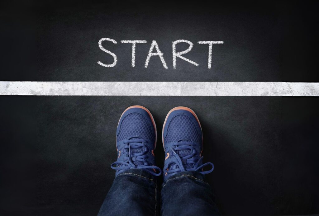 Feet standing at a starting line symbolizing faith to begin with courage without clarity and move when God leads.