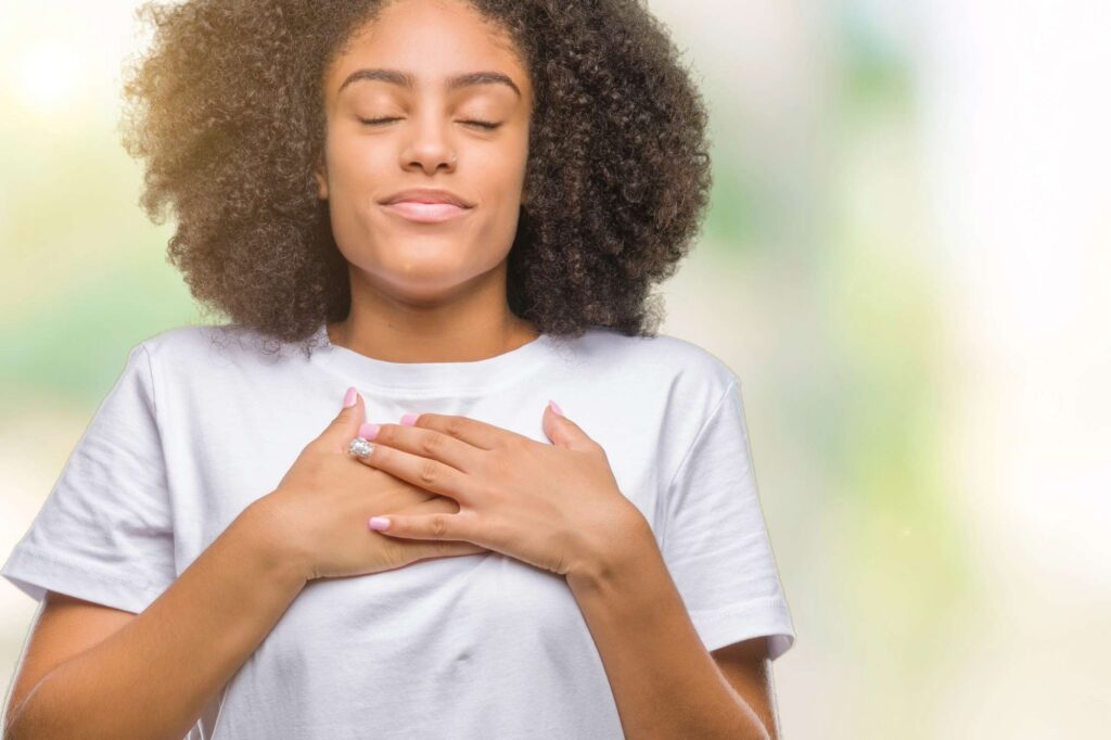 Woman standing before stormy ocean waves, representing finding peace in the storm with God