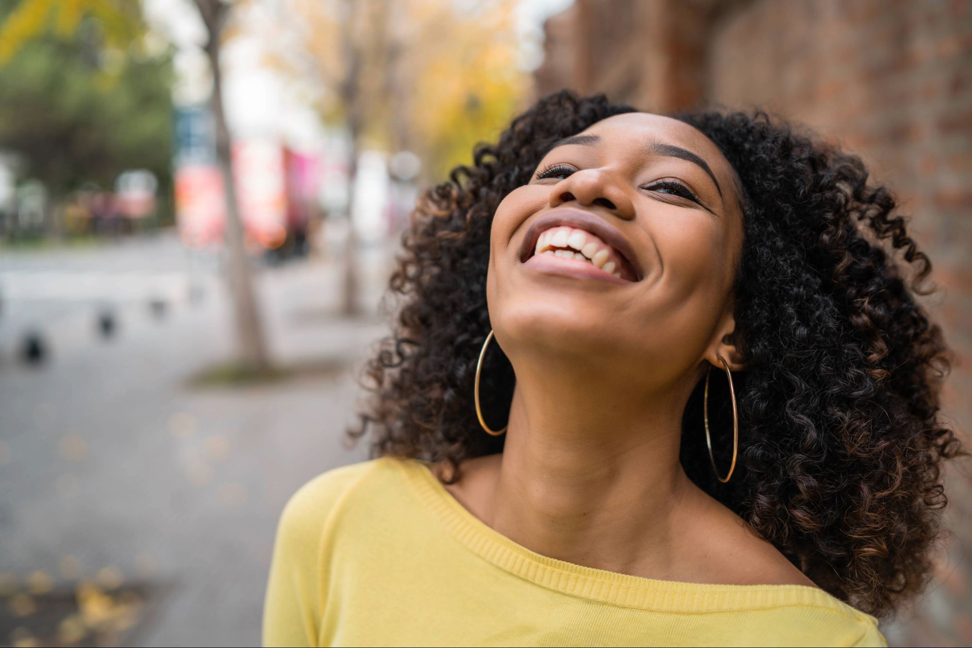 Woman smiling upward with joy and freedom, representing rekindling your passion for God through renewed intimacy and relationship